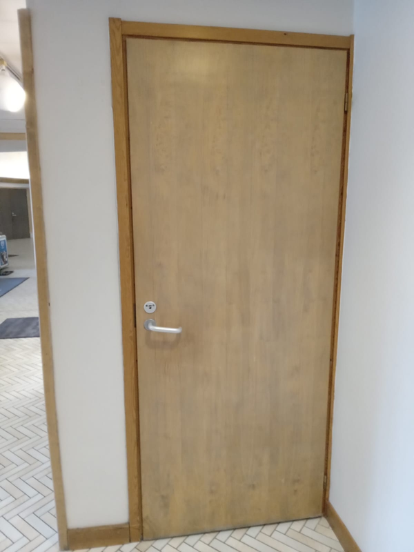 Photo of a beige door, which leads to the wheelchair accessible bathroom